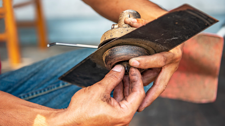 Person holding lawn mower blades