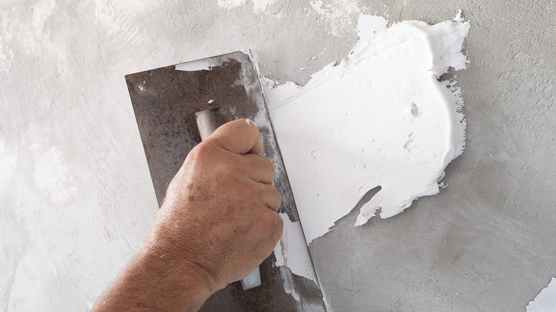 man applying stucco patch