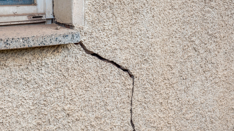 diagonal stucco crack near window