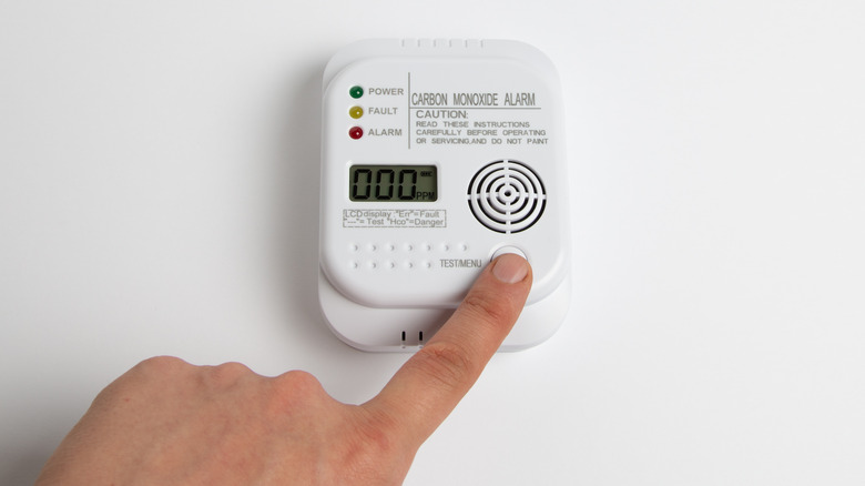 Person testing CO alarm