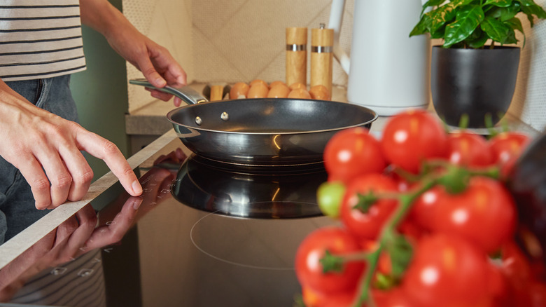 Person placing pan on induction stove