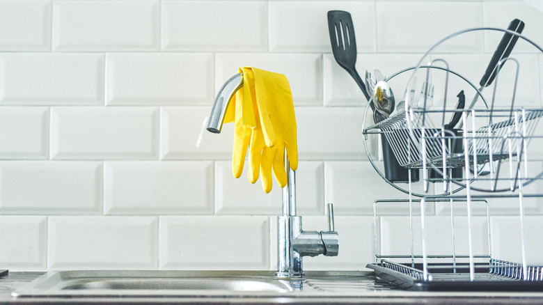 Rubber gloves hang from faucet