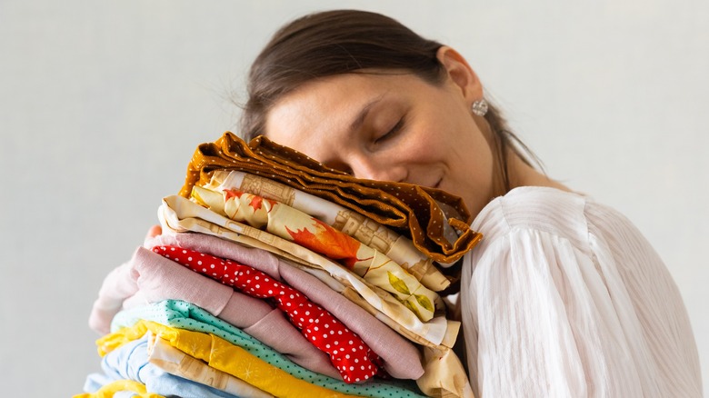 Woman resting face on folded clothes