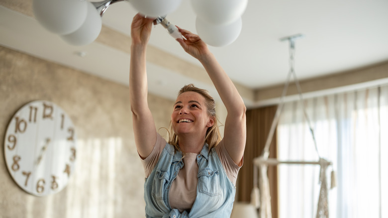 woman replacing lightbulb 