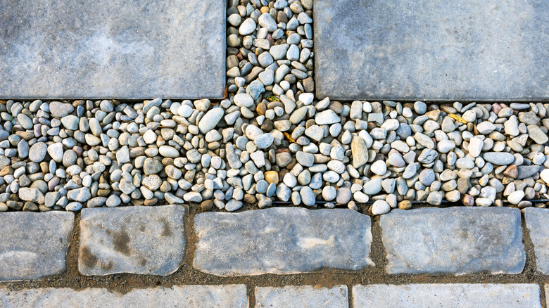 Pea-sized gravel in between pavers and stepping blocks in a landscaping project.