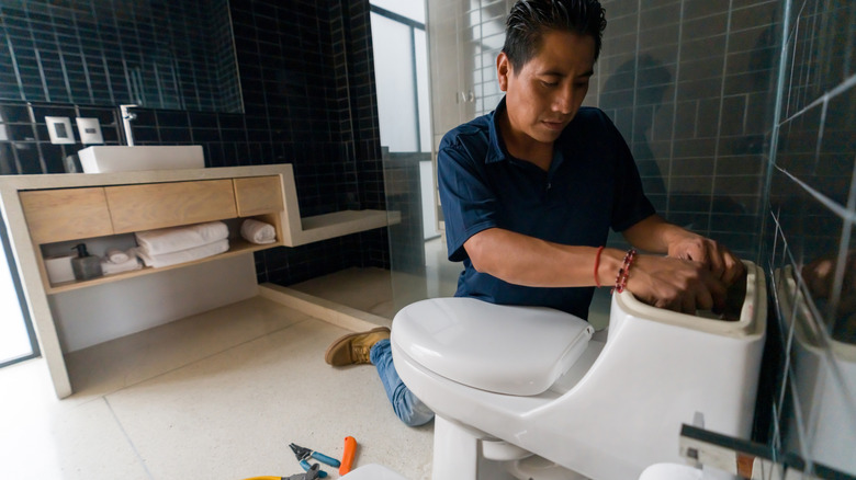 plumber working on toilet