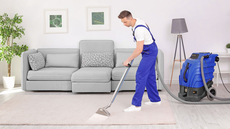 Person steam cleaning carpet