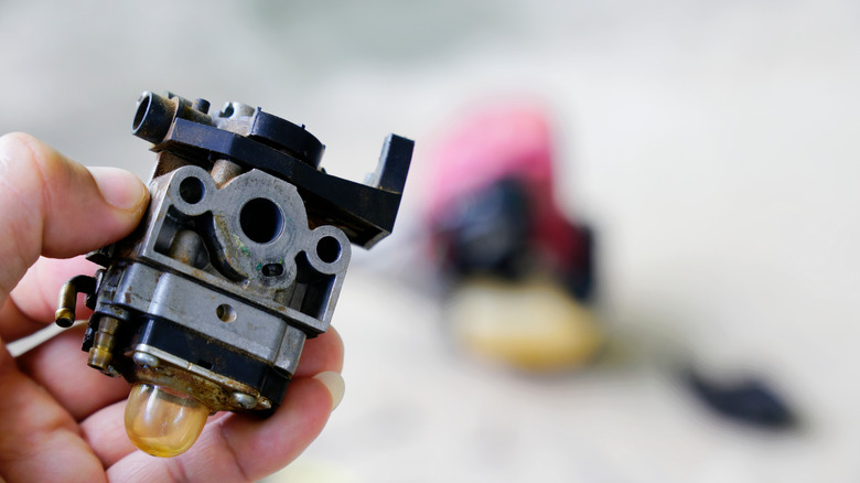 Holding a mower carburetor