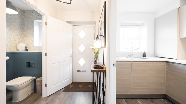 A bathroom situation next to home entryway across from the kitchen