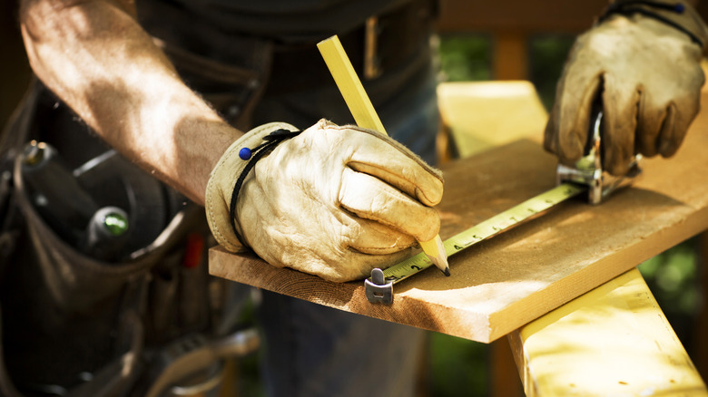 Man marking wood measurements