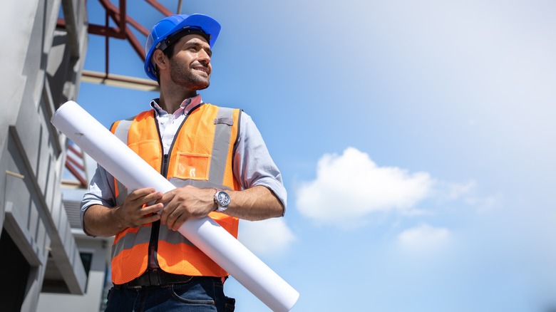 Construction guy holding blueprints