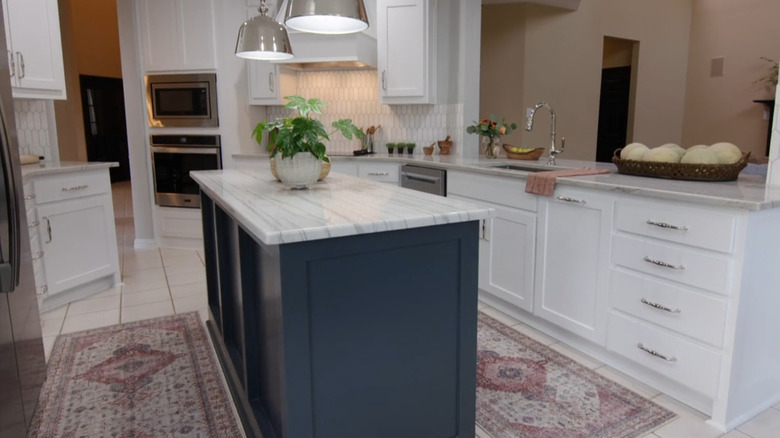 A blue kitchen island and ornate rugs