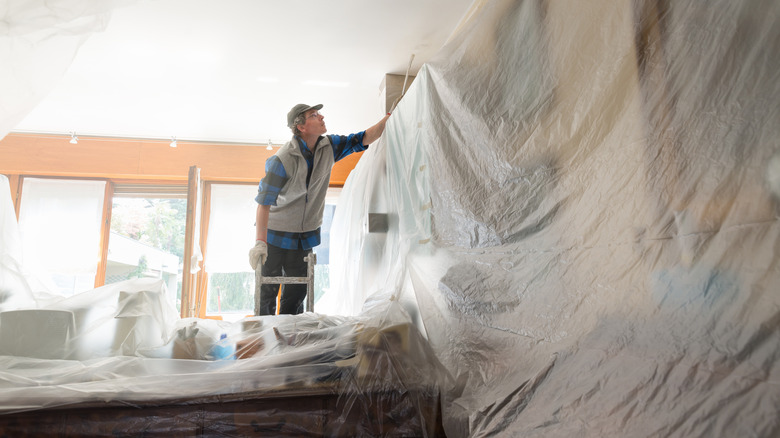 A person using a tarp to prep a space