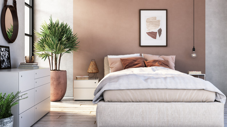 Modern interior of bedroom with colored wall behind bed