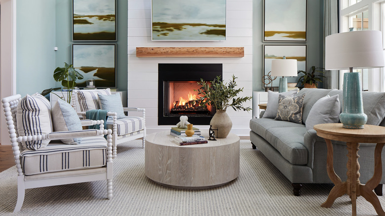 Two white spindle chairs face a light blue couch in a large great room