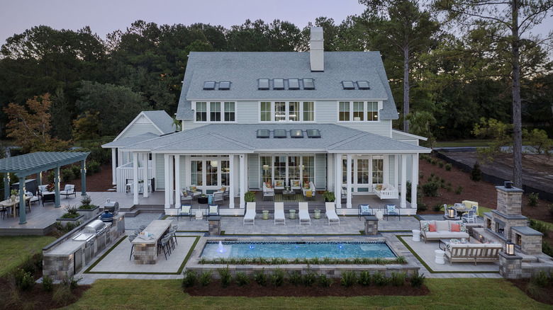 Large 2-story home with veranda and pool, viewed from back yard