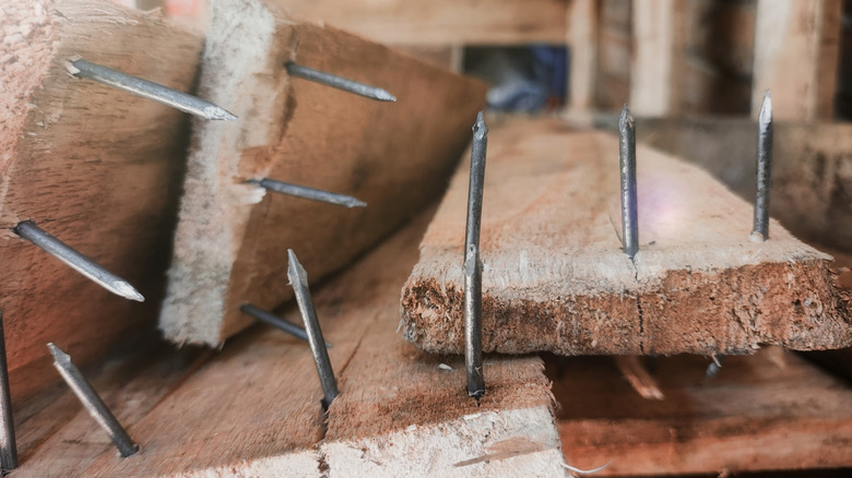 Reclaimed wood with multiple nails sticking out of the material