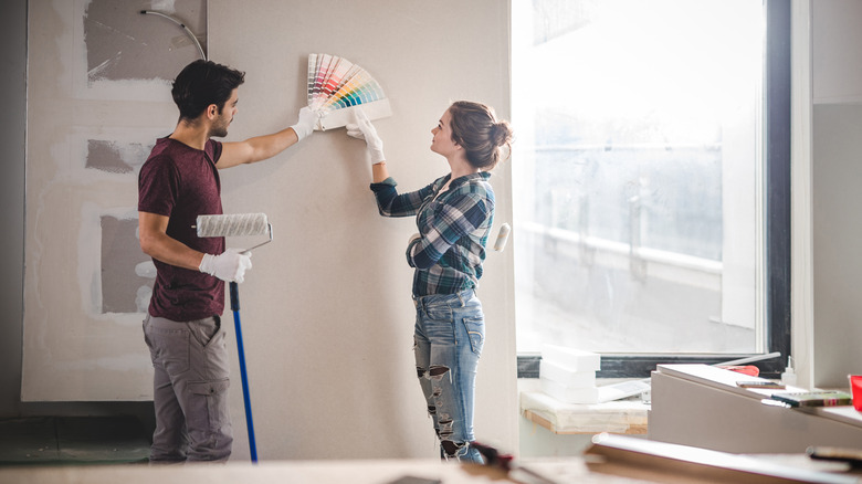 A couple choosing the right color for their wall