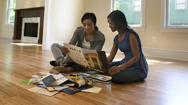 Two women sitting on a floor reading