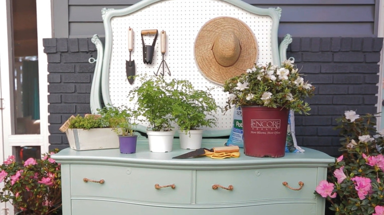 An upcycled dresser turned into a potting bench with a pegboard