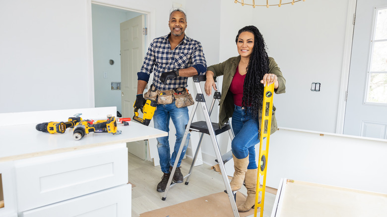 Egypt Sherrod and Mike Jackson posing with tools and stepladder