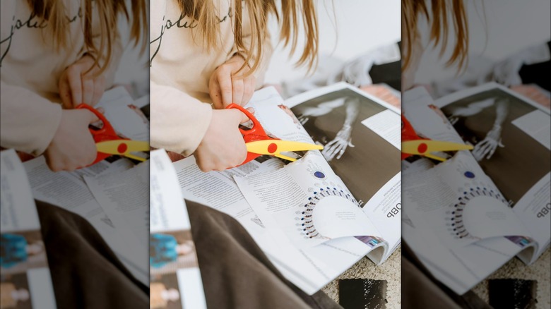 woman cutting out magazine