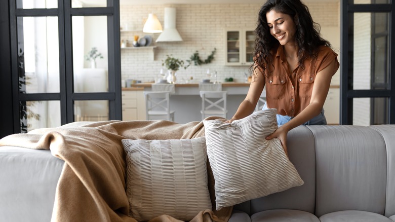 woman decorating with throw pillows