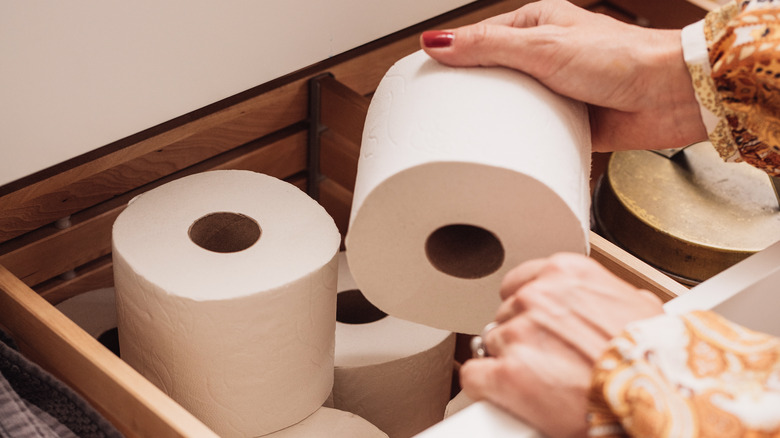 Woman taking toilet paper out