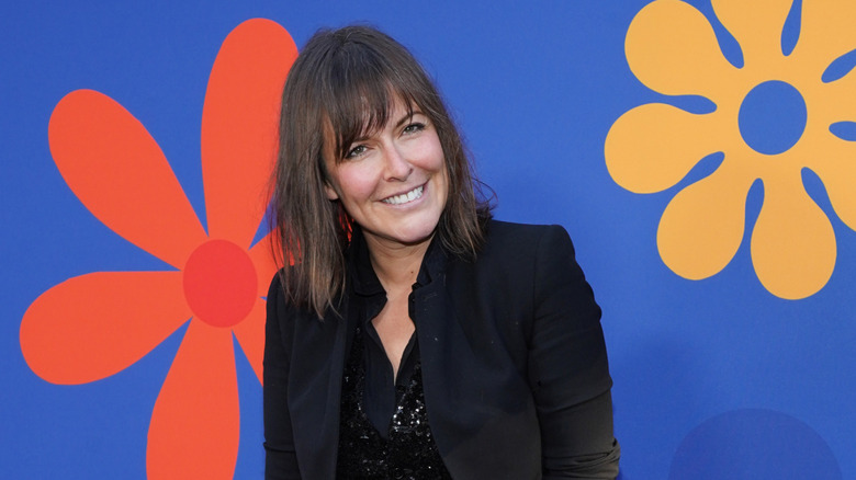 Leanne Ford smiling in front of red carpet background