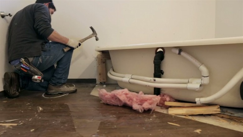 worker removing bathtub