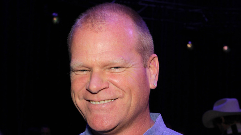 Mike Holmes smiles against dark background