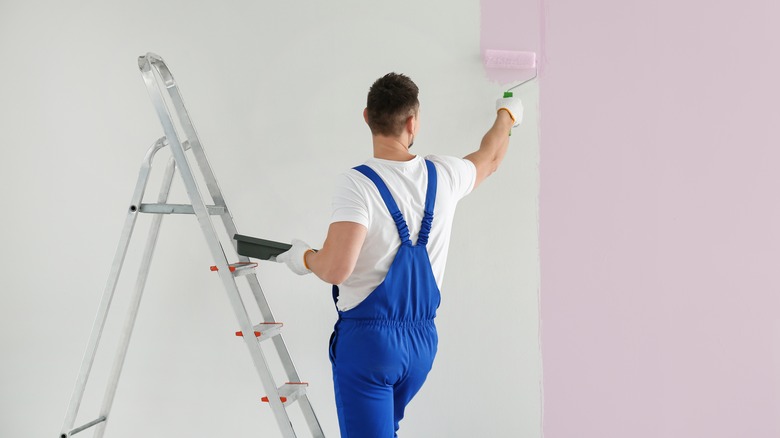 Man painting wall pink