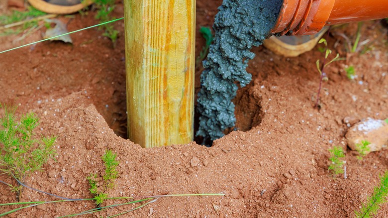 pouring concrete around fence post