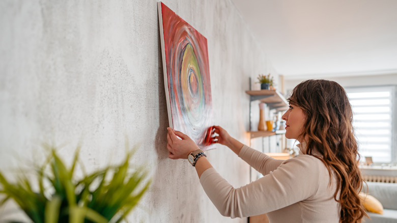 Female putting artwork on the wall