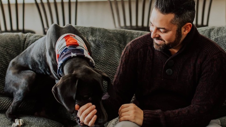 Rico León petting his dog