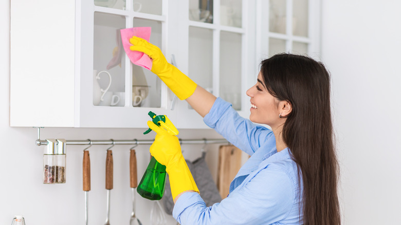 Person cleaning kitchen cabinets