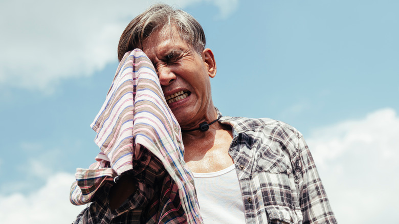 man wiping forehead with towel