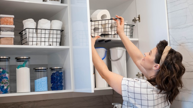 Putting toilet paper in cabinet