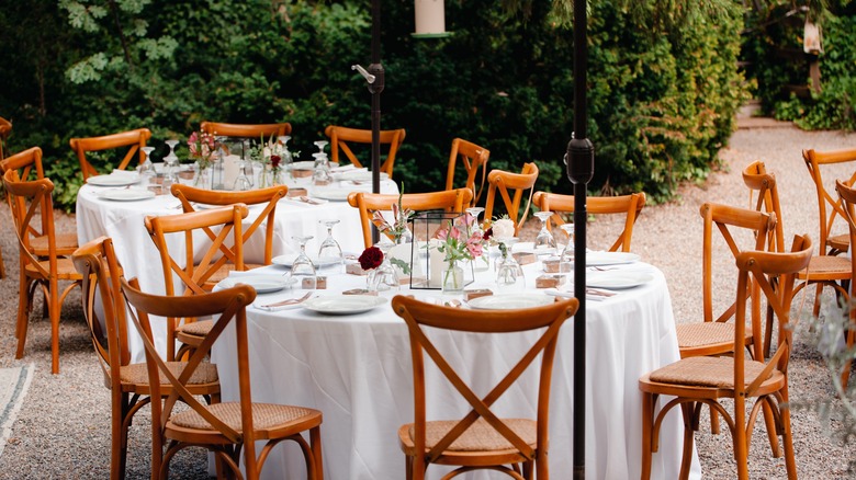 A backyard is decorated with event tables