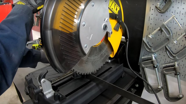 Person cutting metal with a DeWalt miter saw