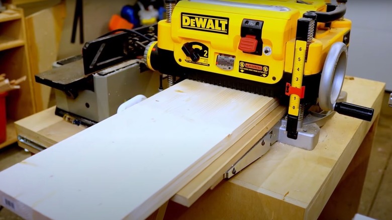 Running wood boards through a power planer