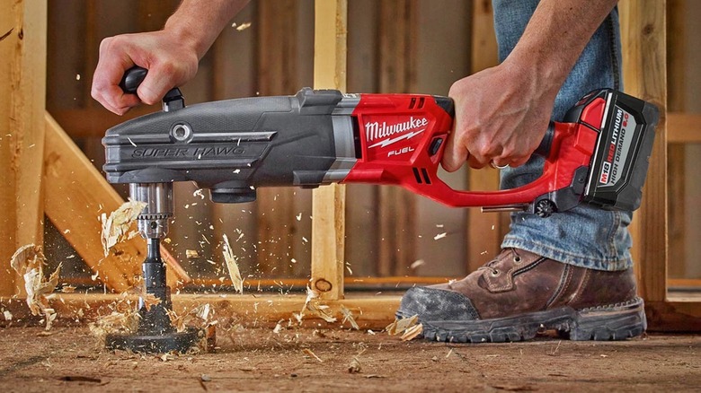 Person drilling a hole with a Milwaukee right angle drill