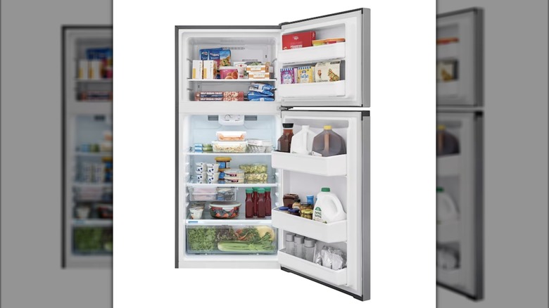 A small stainless steel Frigidaire refrigerator is opened to show shelves full of food