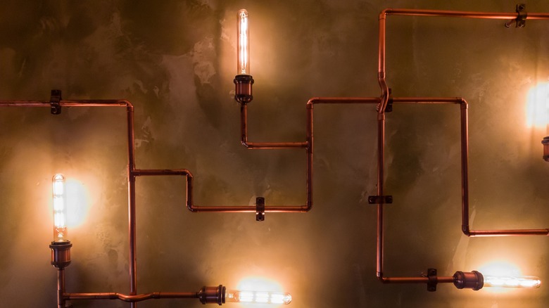 exposed pipes with lights on wall