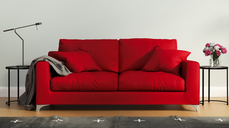 Red cushioned couch with pillows 