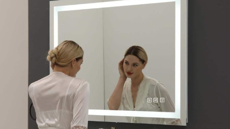 young woman looking in mirror