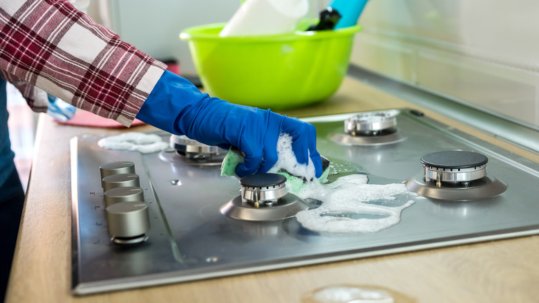 Scrubbing stove in kitchen