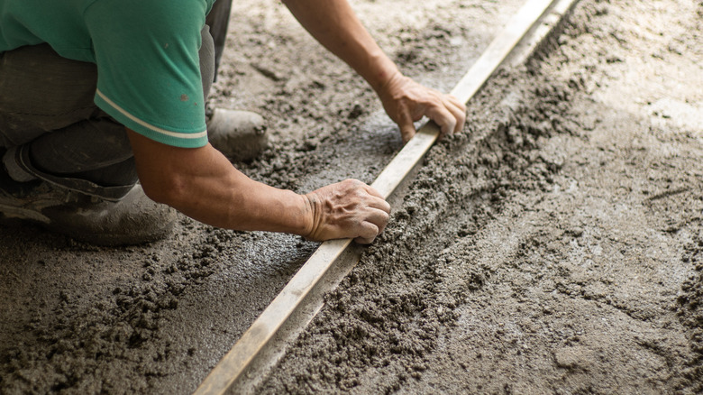 Bare hands leveling wet concrete