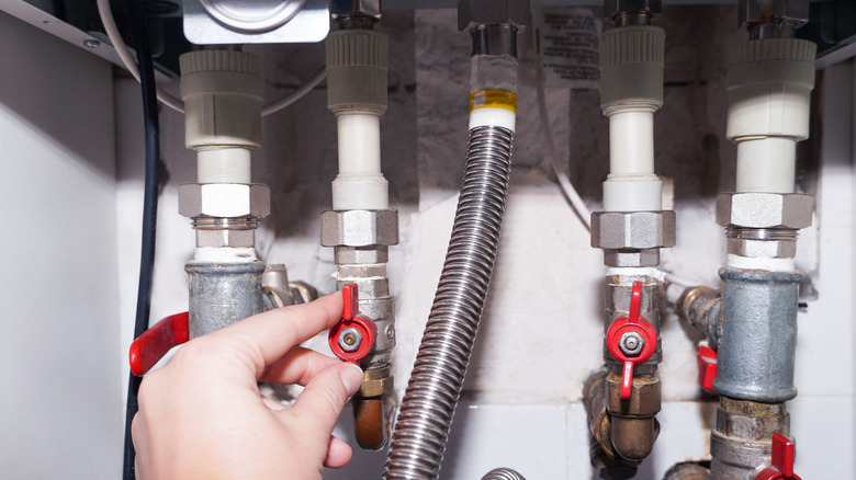 Hands connecting a gas water heater