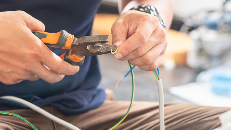 Bare hands connecting two electrical wires